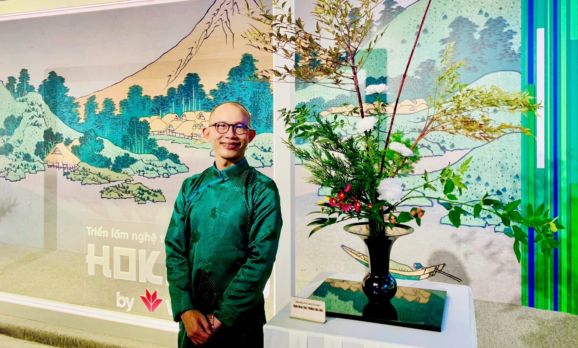 MAI VAN Thai Thomas, professeur ikebana Ikenobo, portrait devant estampe japonaise et arrangement floral                           